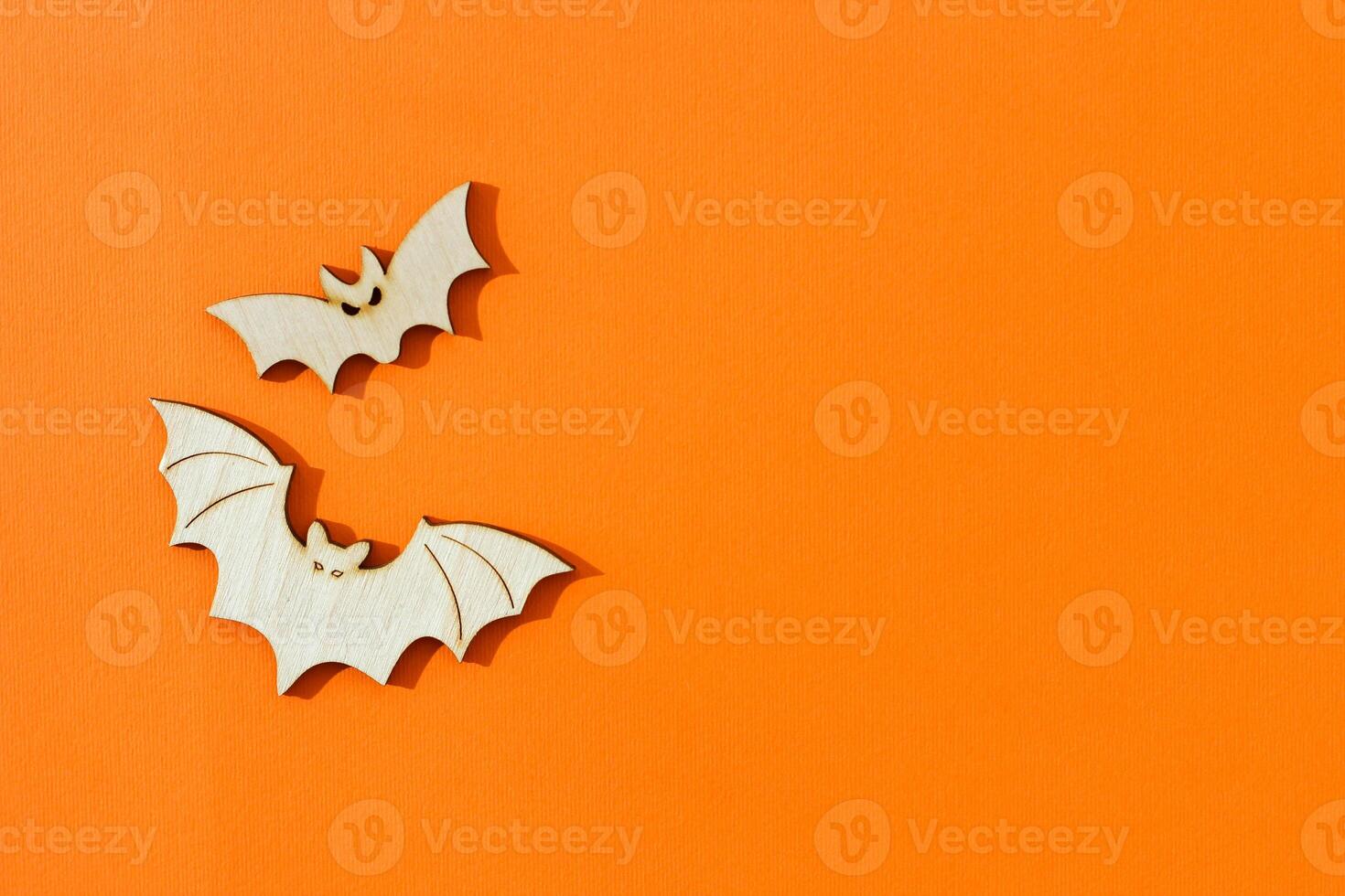 Wooden toy bats on orange background Halloween concept photo