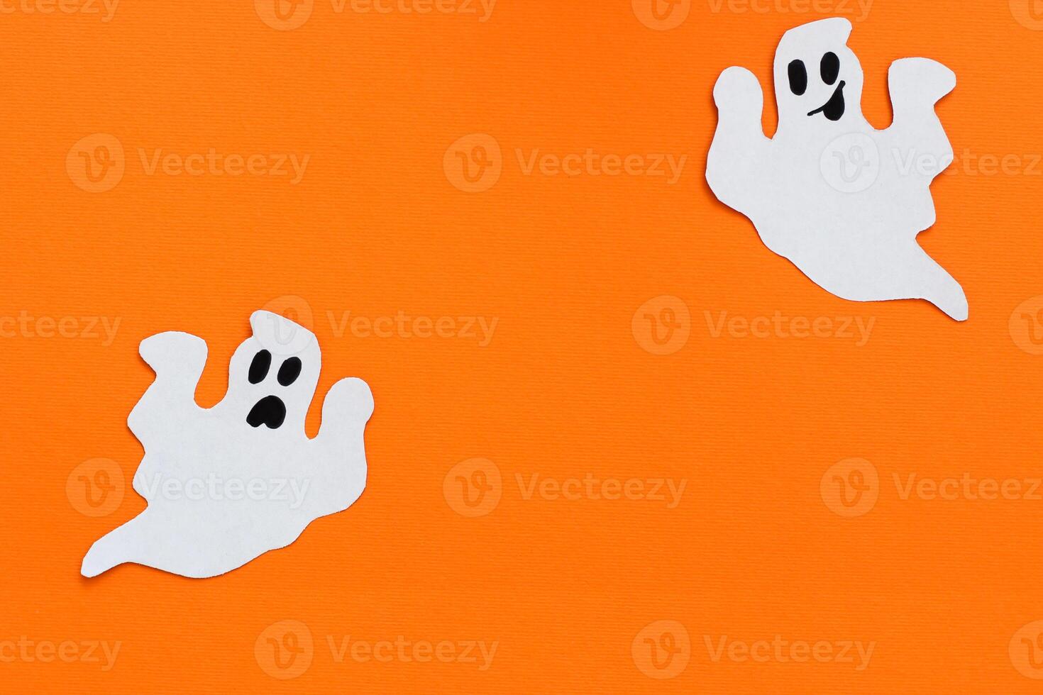 Paper ghosts on an orange background, Halloween concept photo
