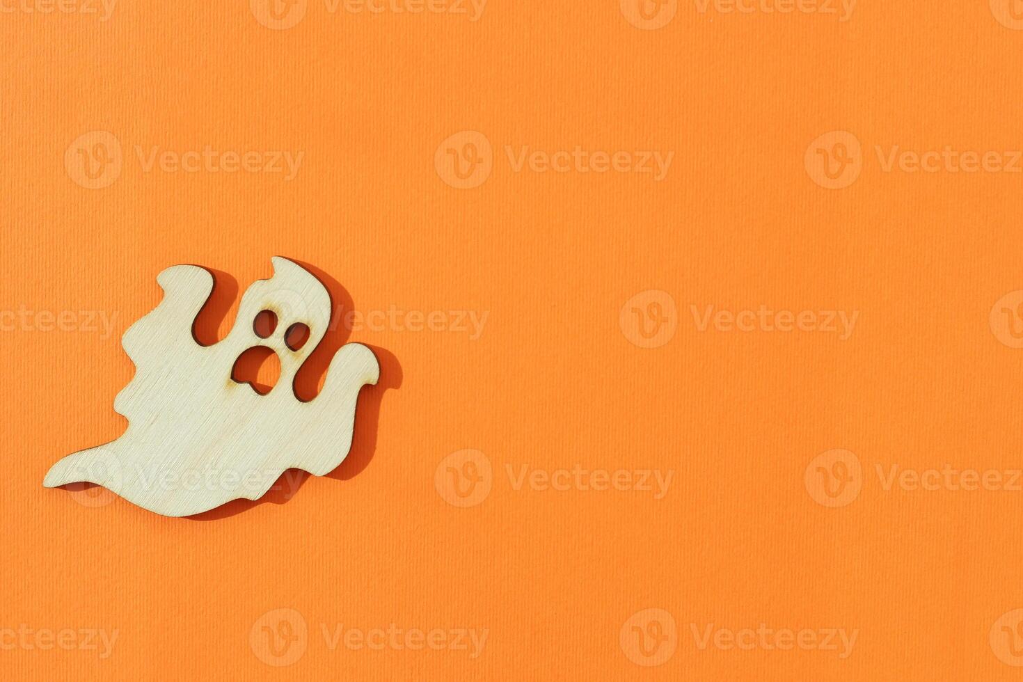 Wooden ghost toy on an orange background, Halloween concept photo