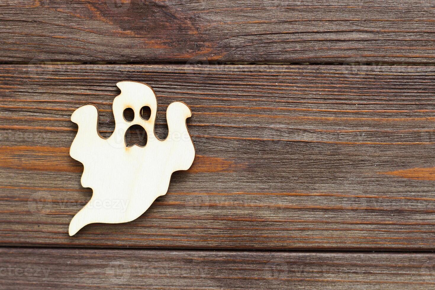 Wooden ghost toy on a wooden background, Halloween concept photo