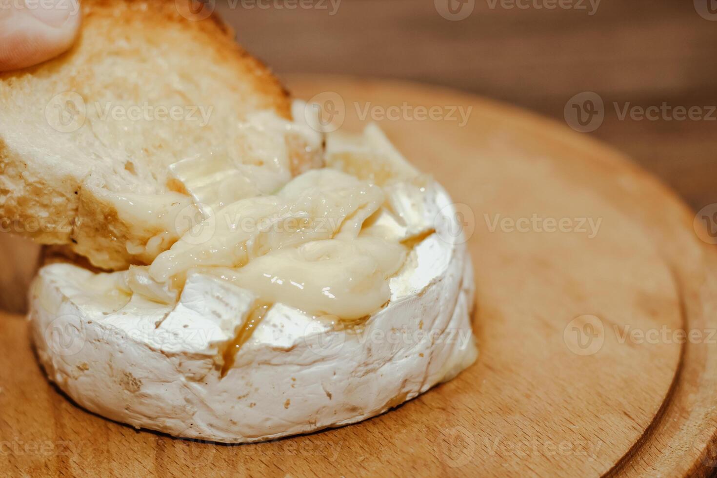 White baguette with olive oil and baked Camembert cheese on the table. photo