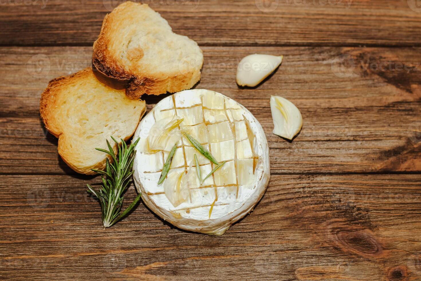 White baguette cut into pieces with olive oil and Camembert cheese on the table. photo