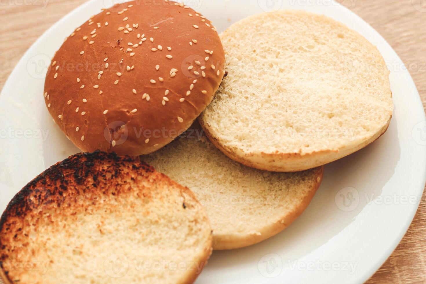 Buns for homemade burgers lie on a plate. photo