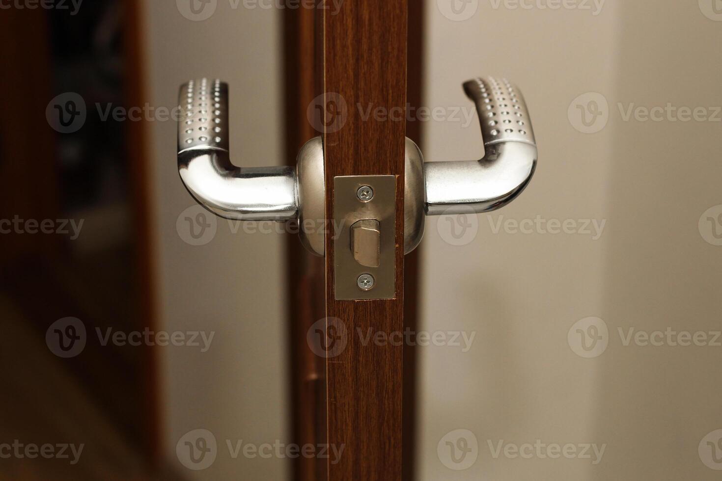A door lock with a handle on the door in the apartment photo