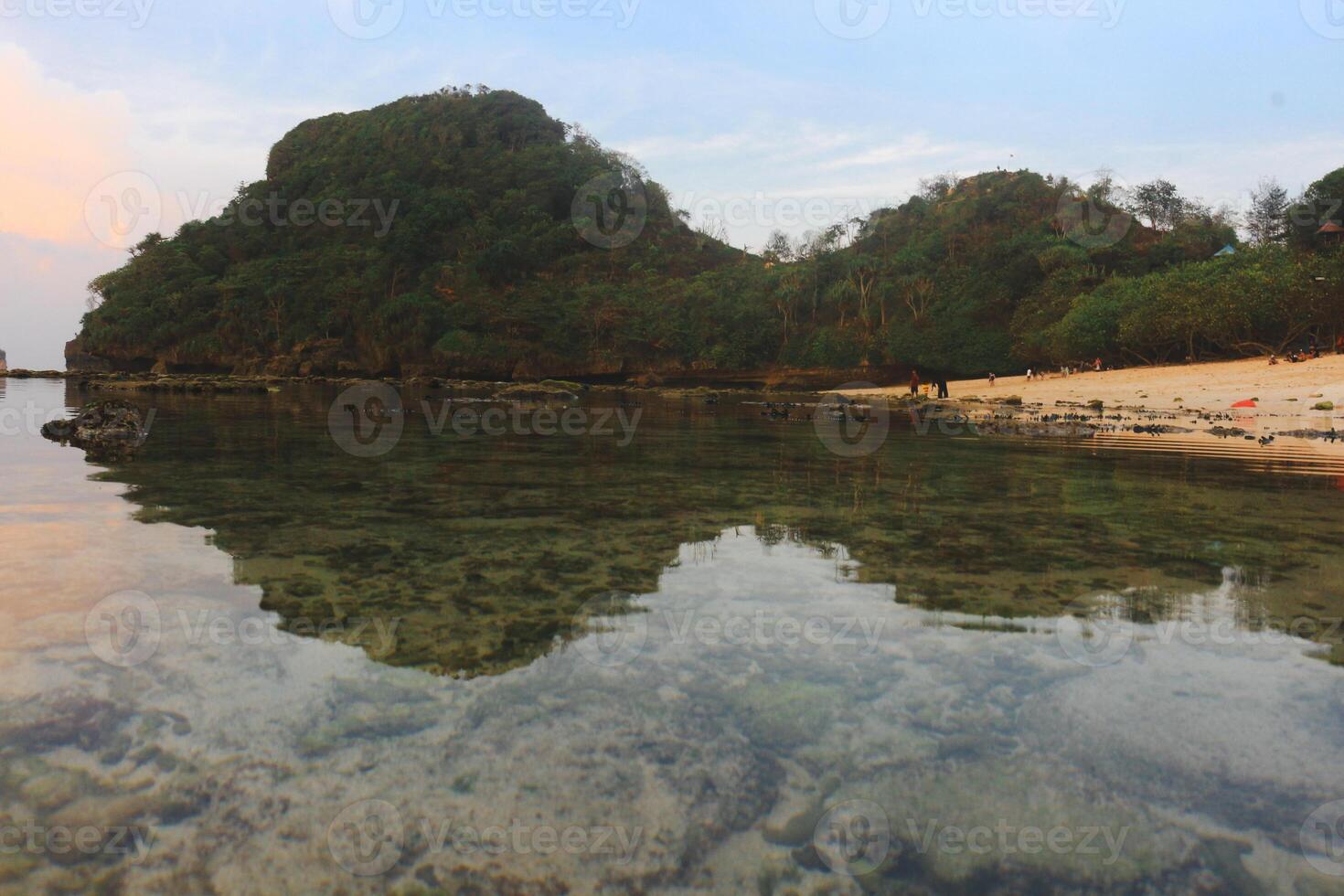 Malang's Tri-Color Coastal Vista, where azure waves meet golden sands under a vibrant sky photo