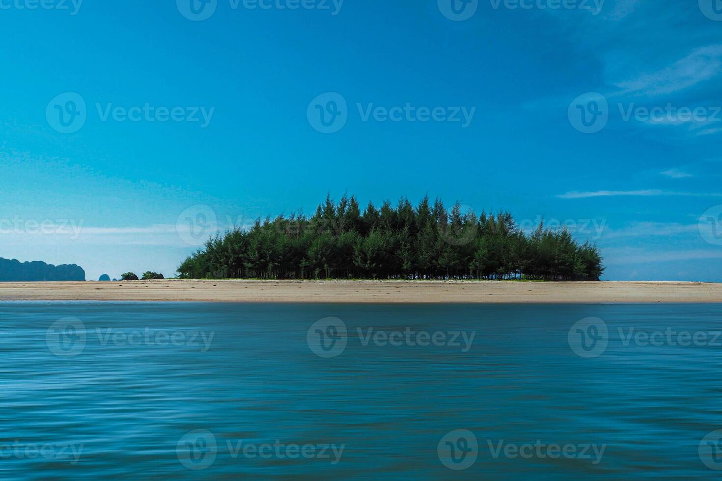 Aerial panorama of Thailand's verdant, lush tropical island, National Park Island, with blue and aquamarine the sea, and clouds shining by sunlight in the background. photo