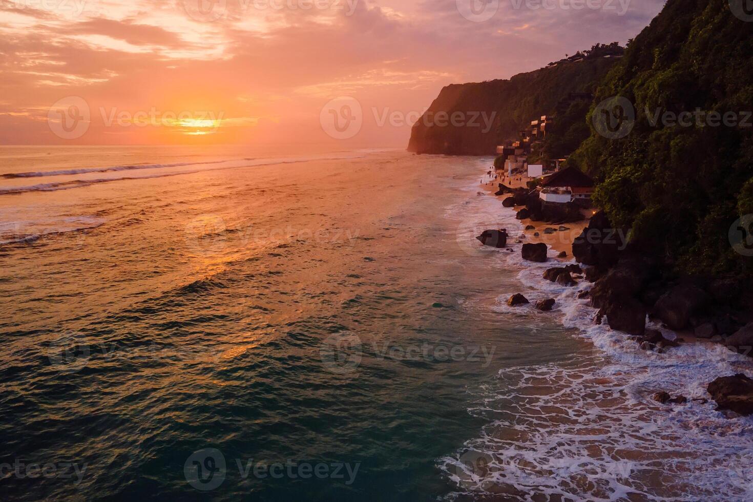 Coastline beach with bright sunset or sunrise tones in Bali. Popular destination beach. Aerial view photo
