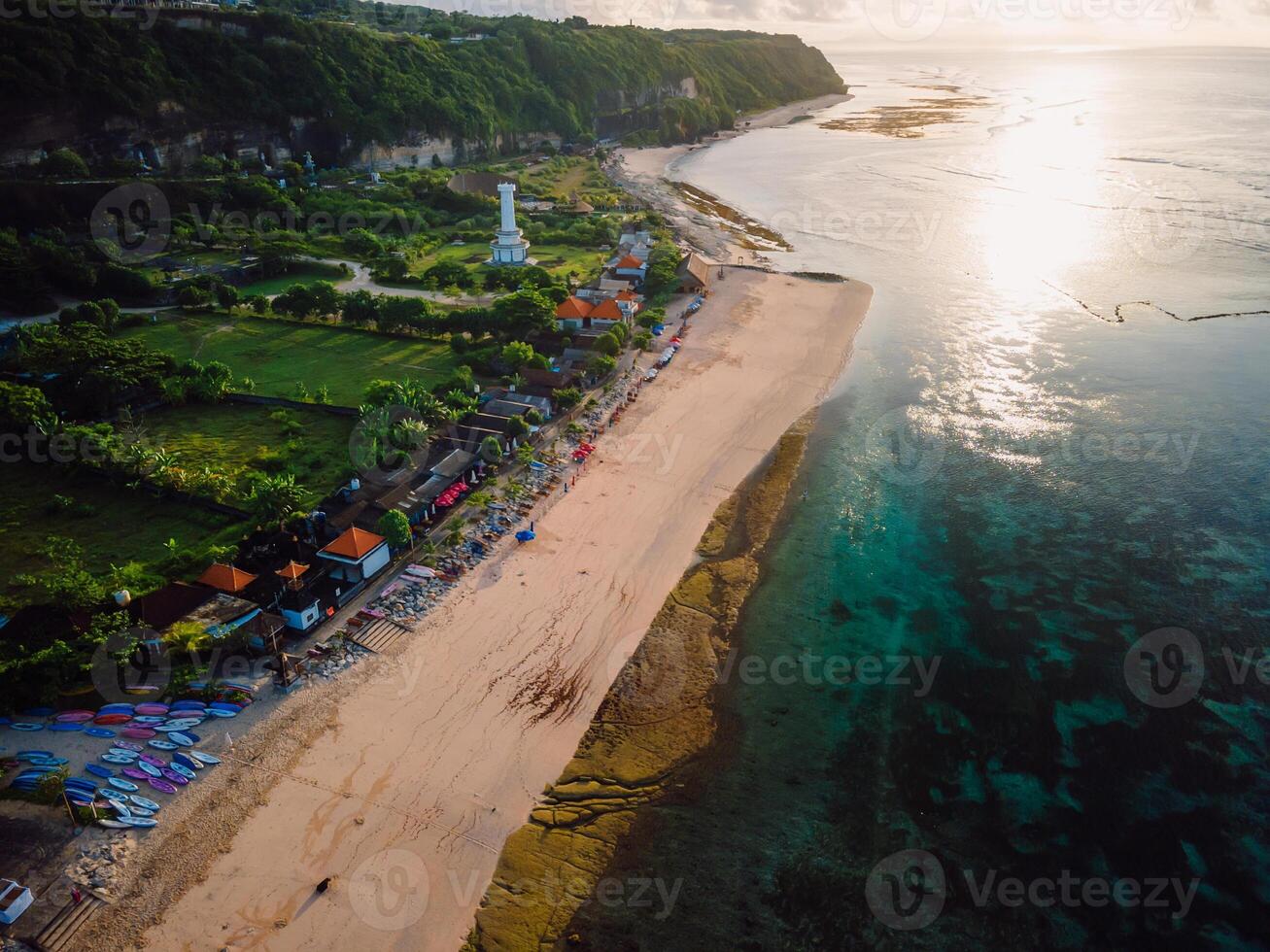 Pandawa beach with lighthouse and ocean at sunrise in Bali. photo