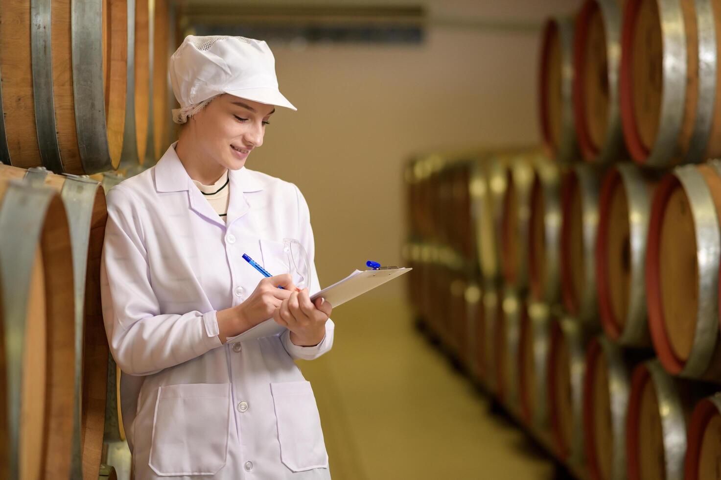 Professional winemaker controlling wine making process and quality at winery factory photo