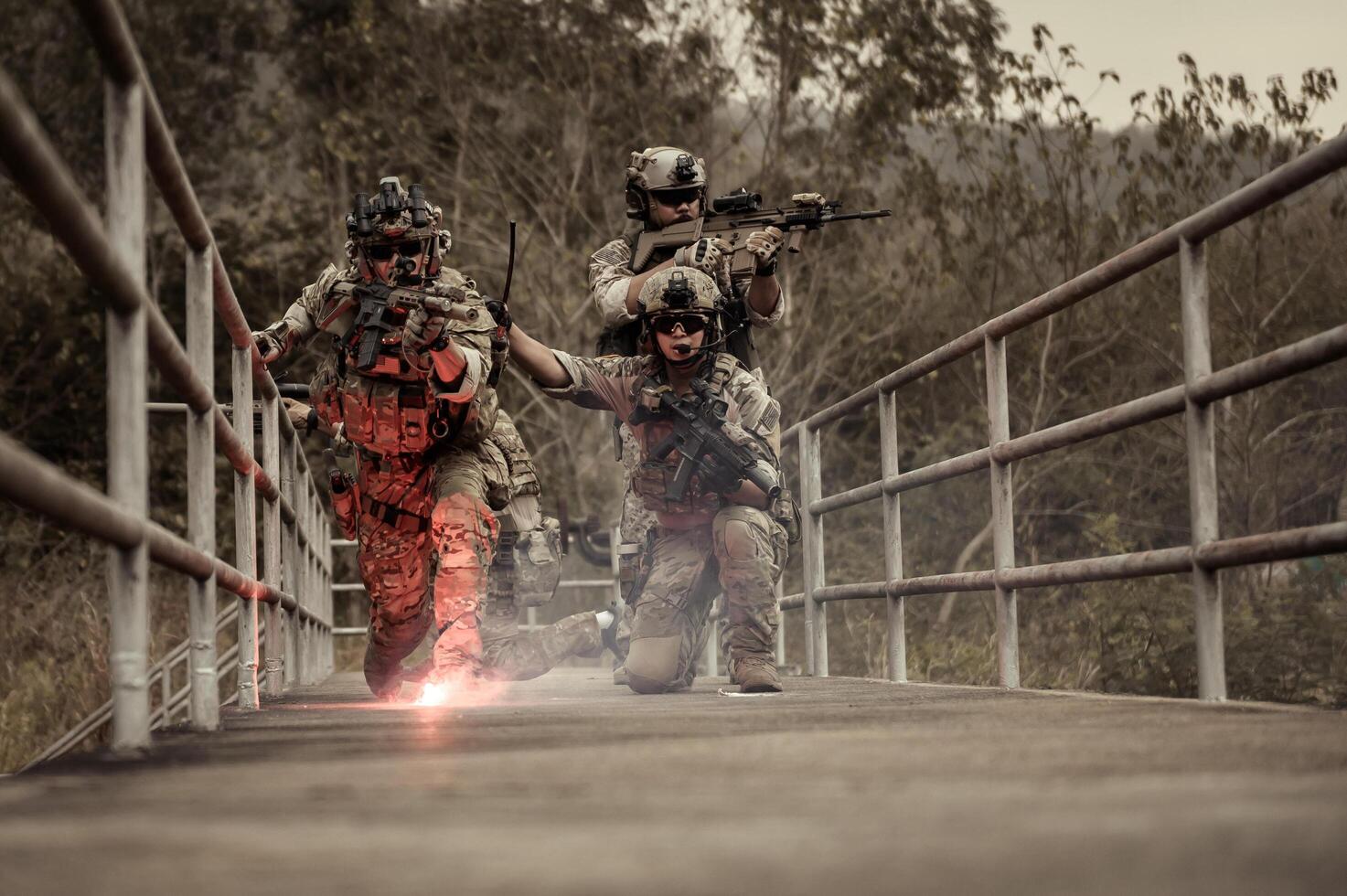 Soldiers in camouflage uniforms aiming with their rifles ready to fire during Military Operation in the forest , soldiers training in a military operation photo