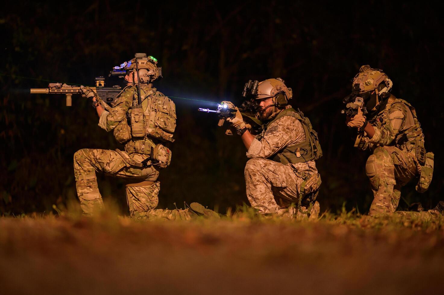 Soldiers in camouflage uniforms aiming with their riflesready to fire during Military Operation at night soldiers training in a military operation photo