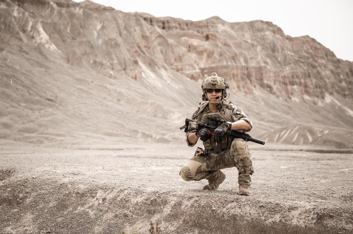 soldados en camuflaje uniformes puntería con su rifles listos a fuego durante militar operación en el Desierto soldados formación en un militar operación foto