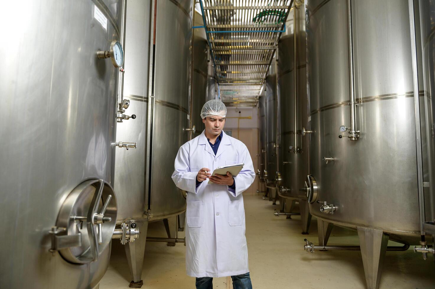 Professional winemaker controlling wine making process and quality at winery factory photo