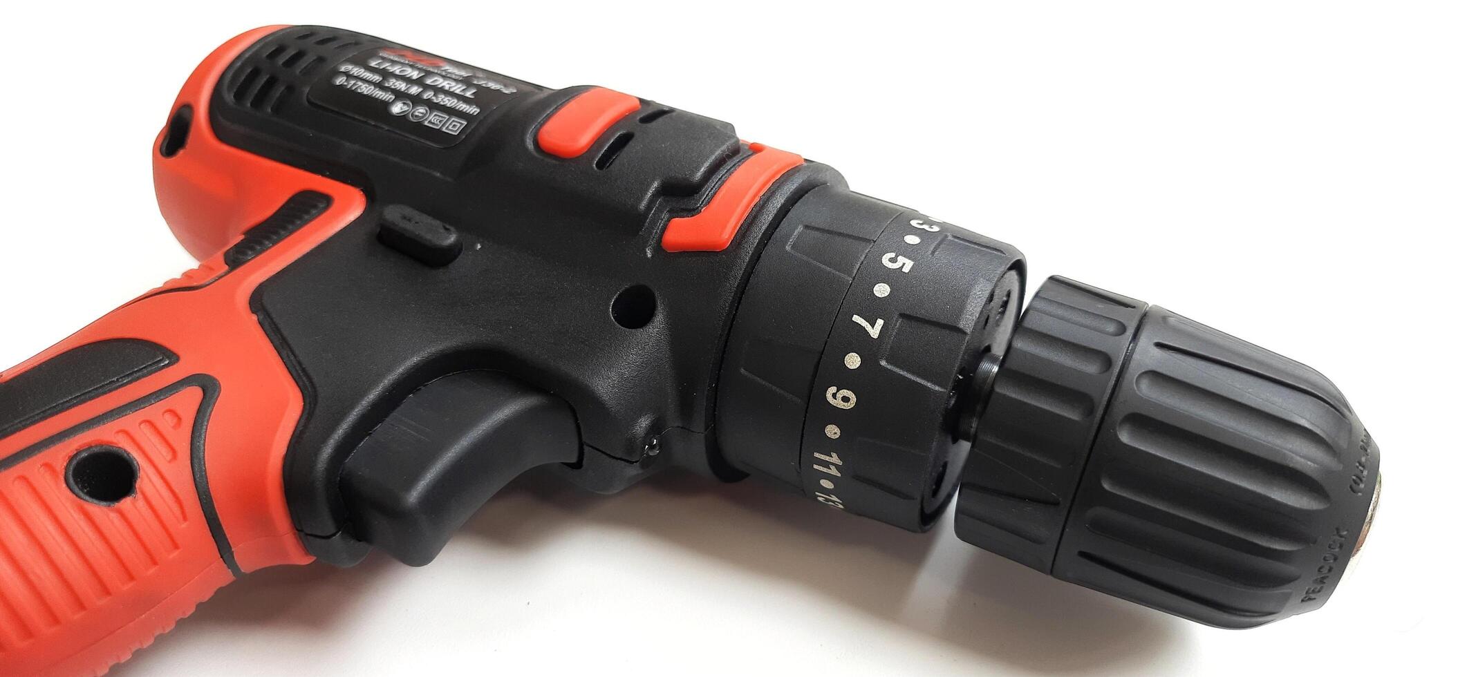Electric red cordless screwdriver drill with charge the battery isolated on white background. Professional home repair tool. Bekasi, West Java, Indonesia - May 17 2024 photo