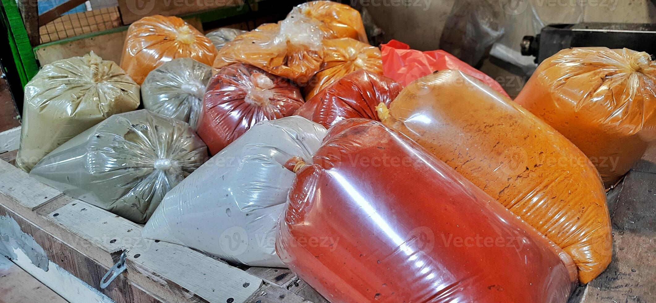 Various condiments or bumbu giling or bumbu halus ingredients in plastic packaging for cuisine, sold in Indonesian local market photo