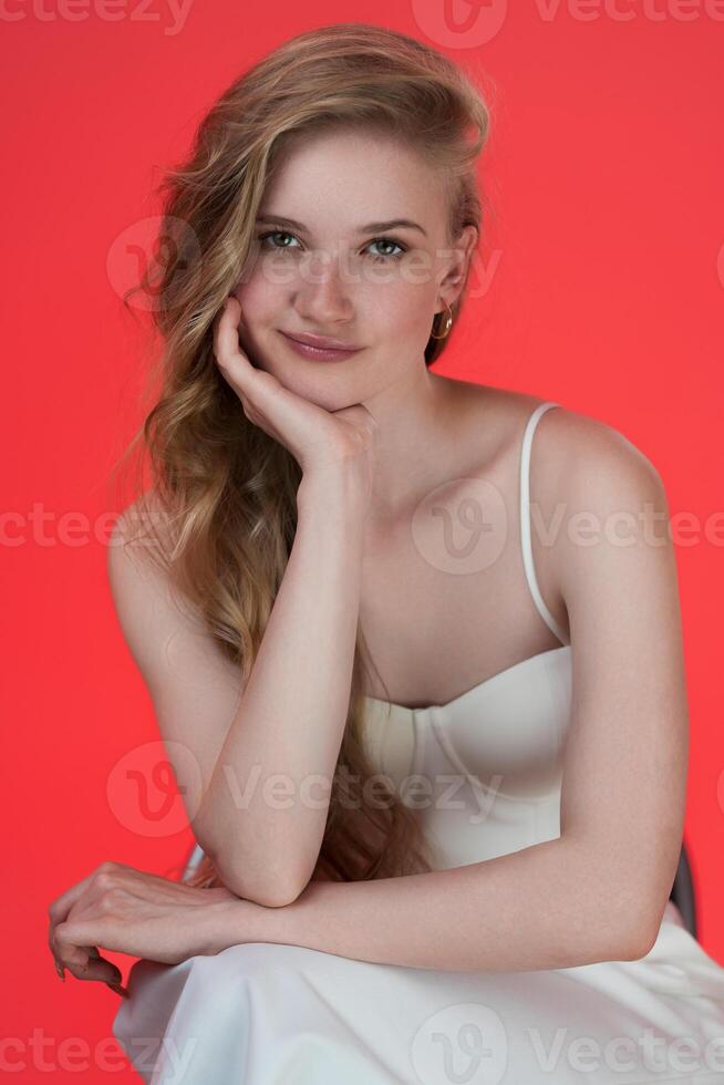 Headshot of young female fashion model from Generation Z resting chin on her palm, looking at camera photo