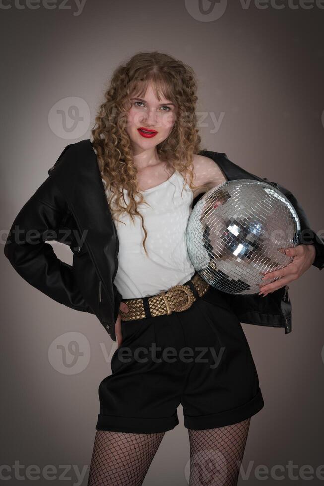 Sensuality woman holding mirror disco ball, looking at camera during celebration party in nightclub photo