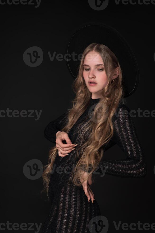 Portrait young blonde woman looking down, exudes beauty and glamour as she poses on black background photo