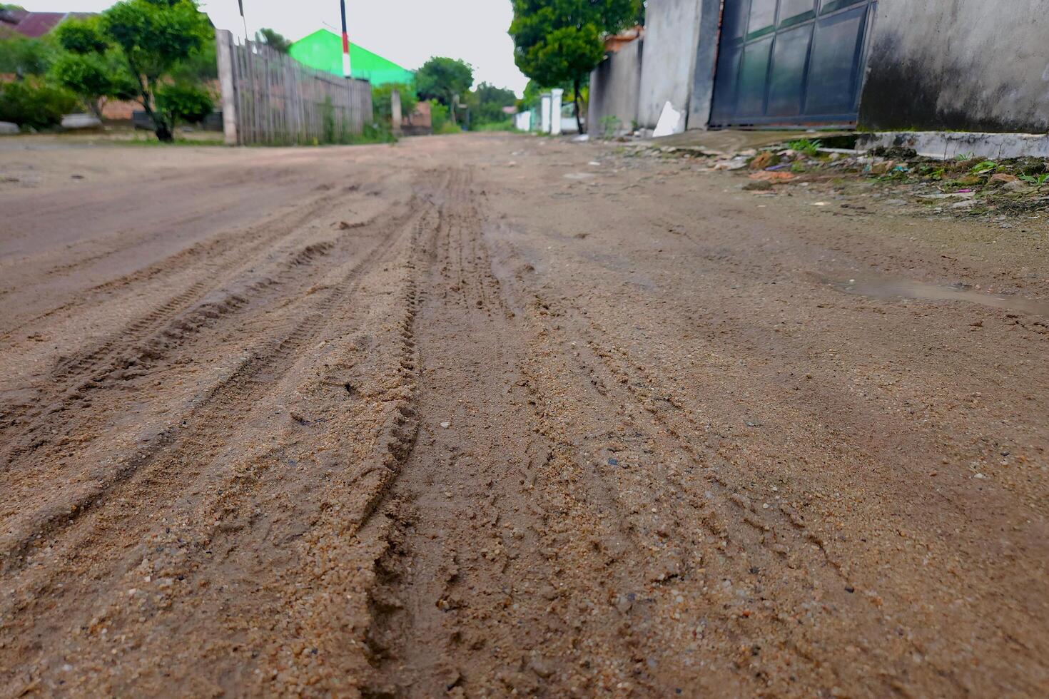view of a dirt road in a village with a natural concept photo