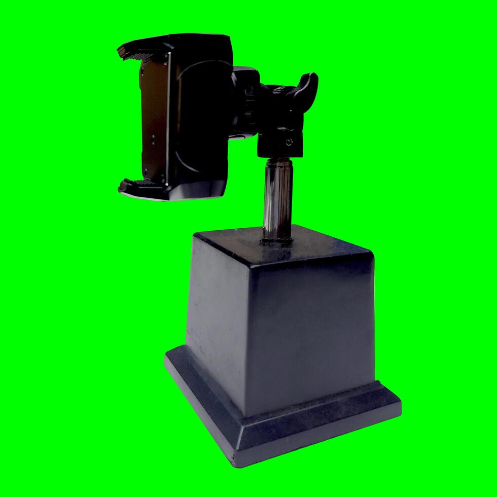 Smartphone holder, tool for photography, made of plastic and stainless with a green background texture photo