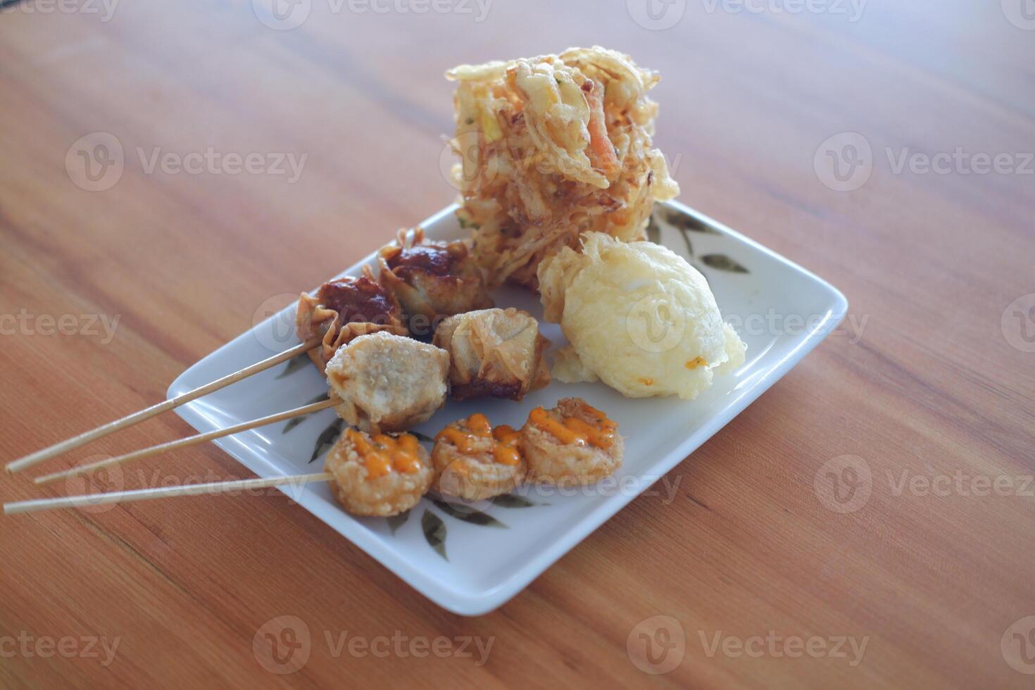 Thai style fried dumpling in a white plate on wooden table photo