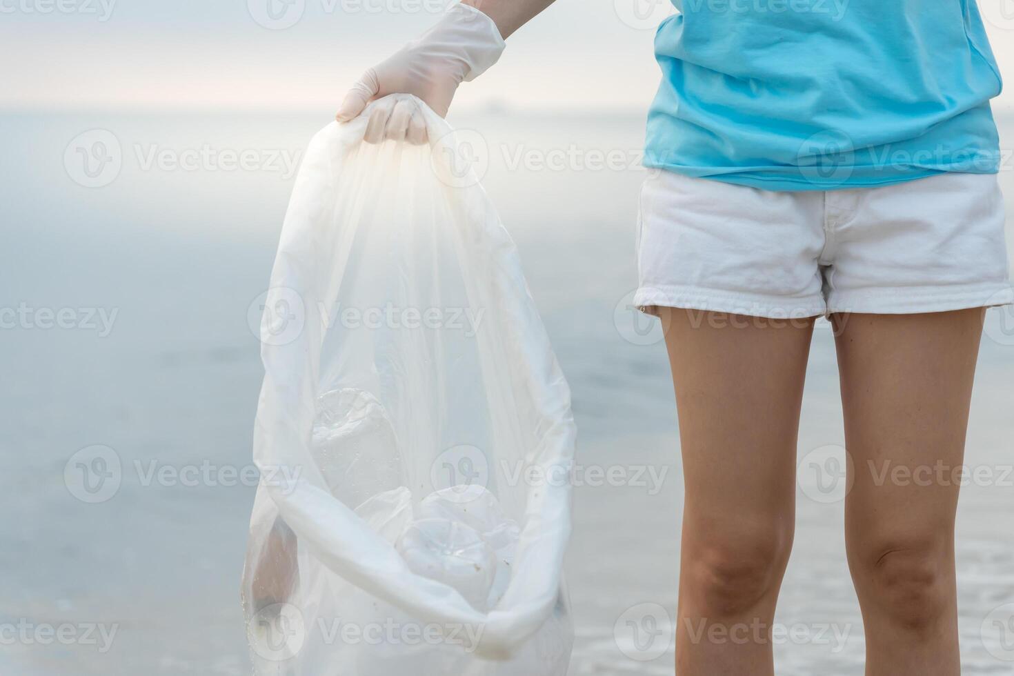 Save water. Volunteer pick up trash garbage at the beach and plastic bottles are difficult decompose prevent harm aquatic life. Earth, Environment, Greening planet, reduce global warming, Save world photo