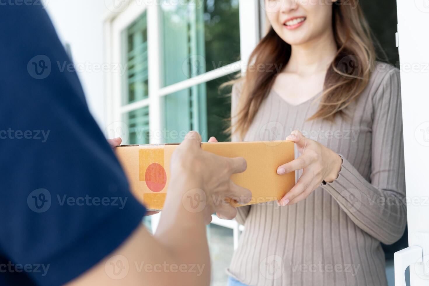 Happy smiling woman receives boxes parcel from courier in front house. Delivery man send deliver express. online shopping, paper containers, takeaway, postman, delivery service, packages photo
