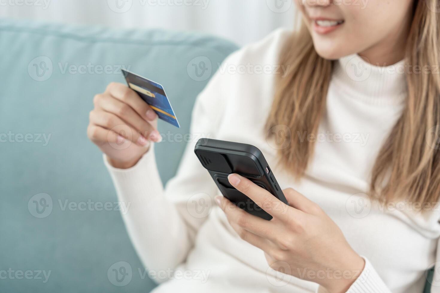 woman using smartphone for online shopping at home. Hand holding mobile phone with payment detail page display and credit card, stay home, technology, electronic commerce, internet, market place photo
