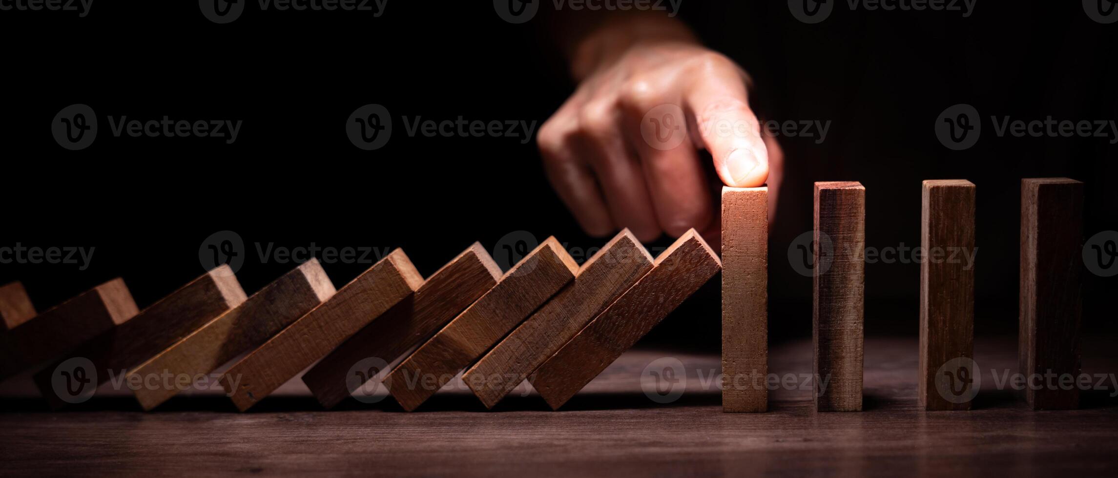 insurance with hands protect domino. Businessman hands stop dominoes falling in business crisis. business risk control and planning and strategies to run prevent insurance businesses. photo