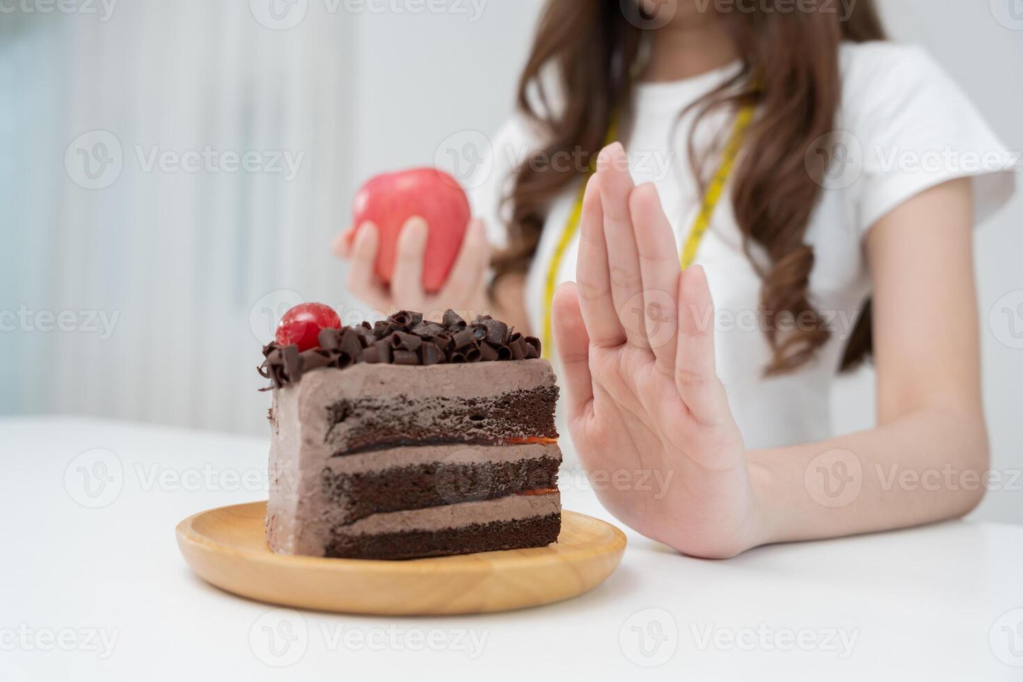 Beauty slim female body confuse chocolate cake. Woman in restaurant achieves weight loss goal for healthy life, crazy about thinness, thin waist, nutritionist. Diet, body shape. photo