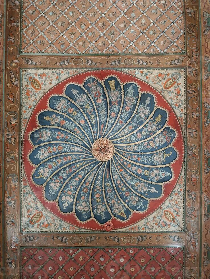 a large blue and red flowered rug with a spiral design on the bottom. photo