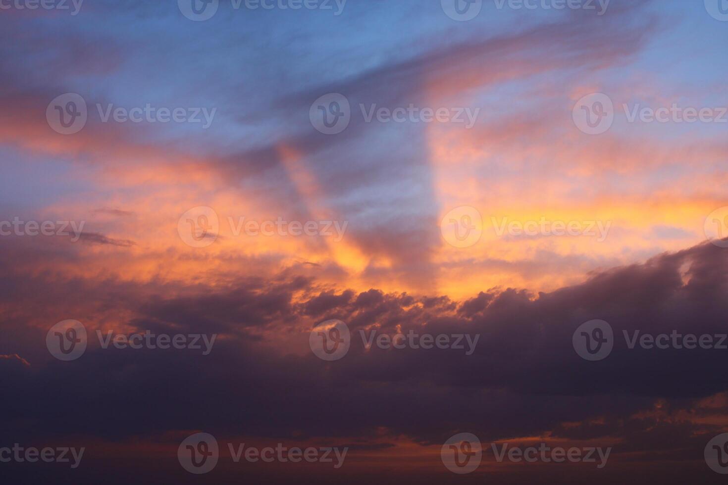 a sunset sky with clouds and a purple sky with a few clouds. photo