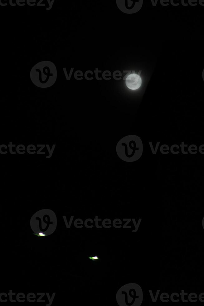 the full moon in the black sky photo