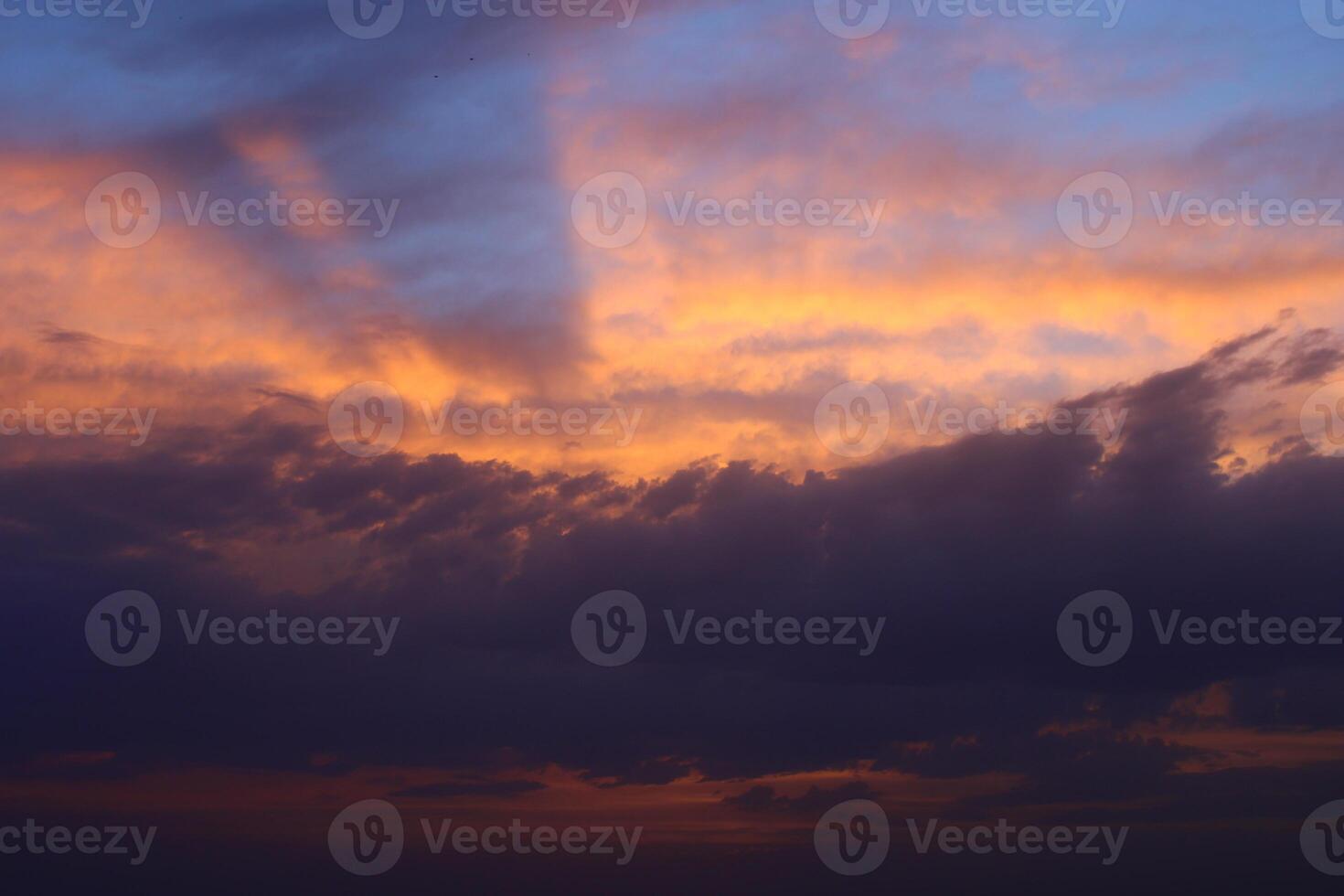 a sunset sky with clouds and a purple sky with a few clouds. photo