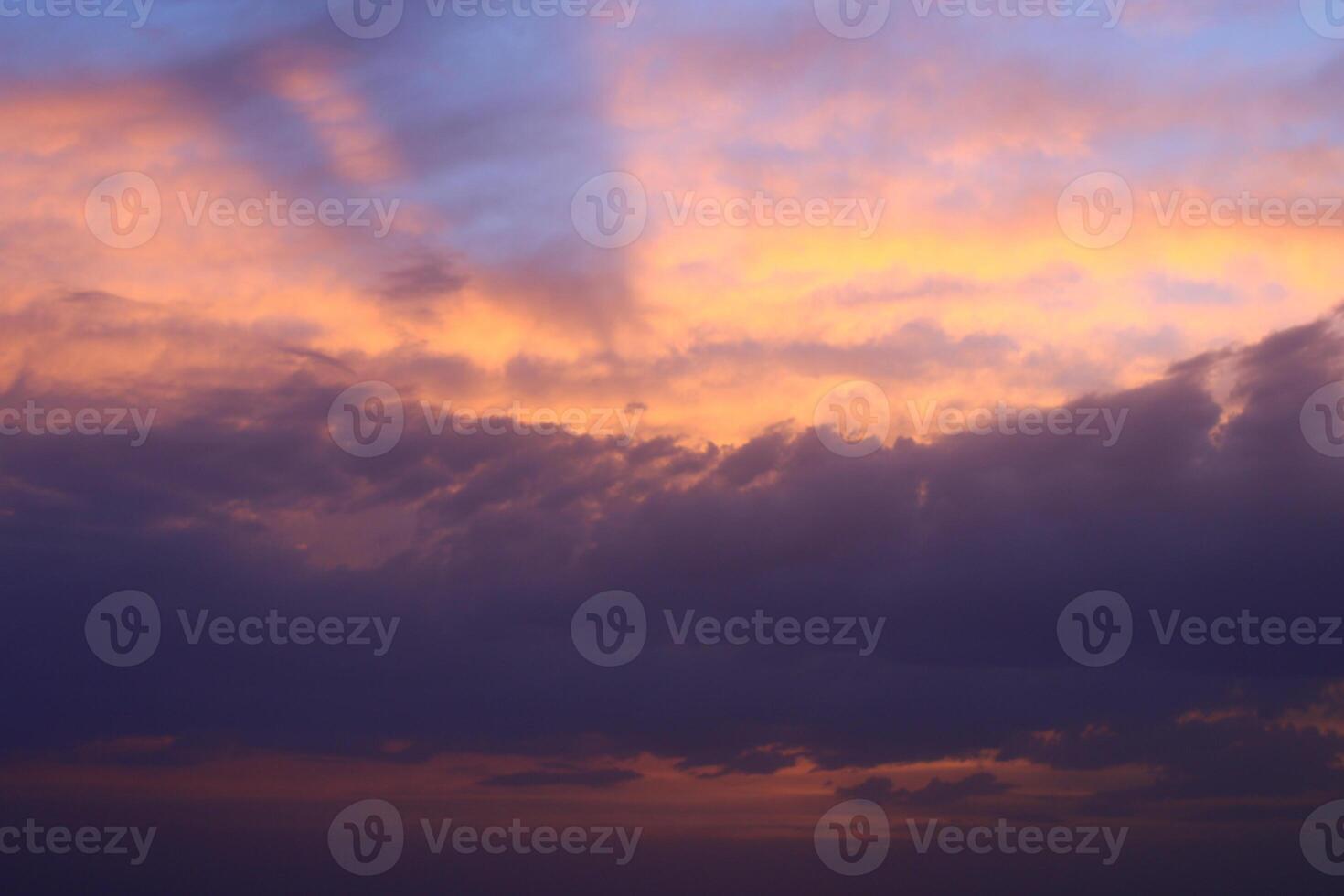 a sunset sky with clouds and a purple sky with a few clouds. photo