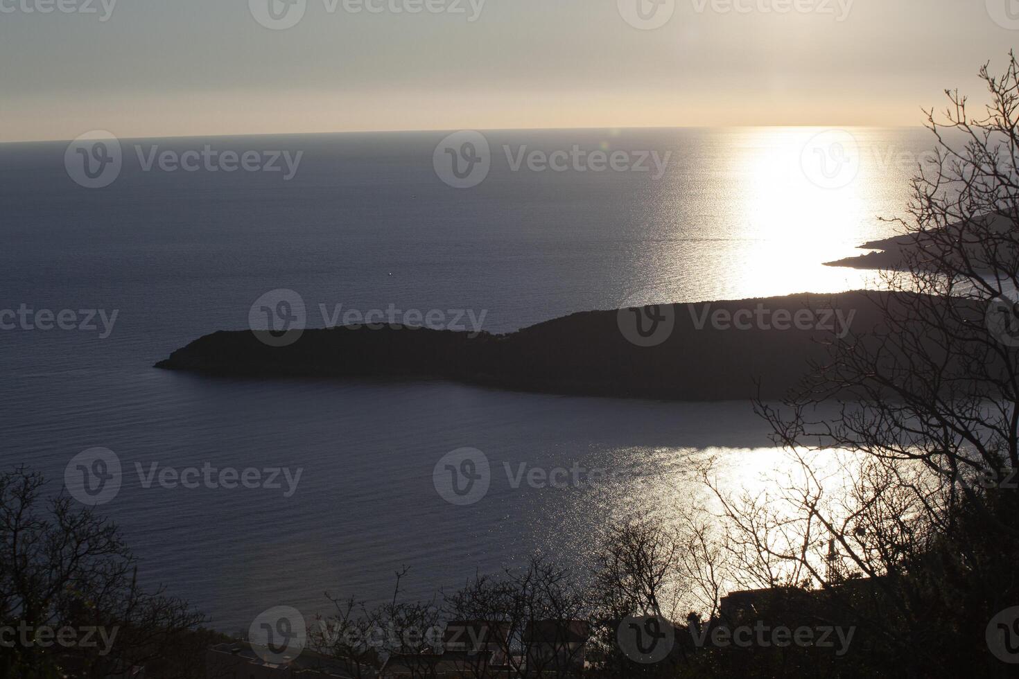 The sea surface of the Adriatic Sea. An island with green trees. View from above. Montenegro. Budva. Horizontal. photo