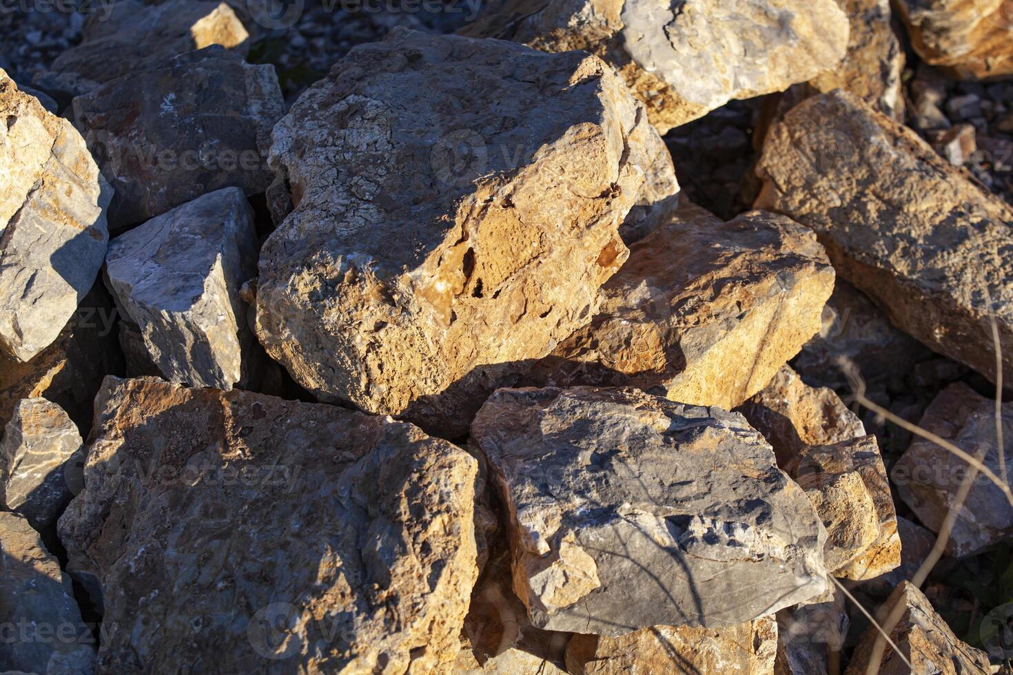 Red rocks of different shapes and sizes on the ground. Orange texture. Background. For text. For banner. Horizontal photo