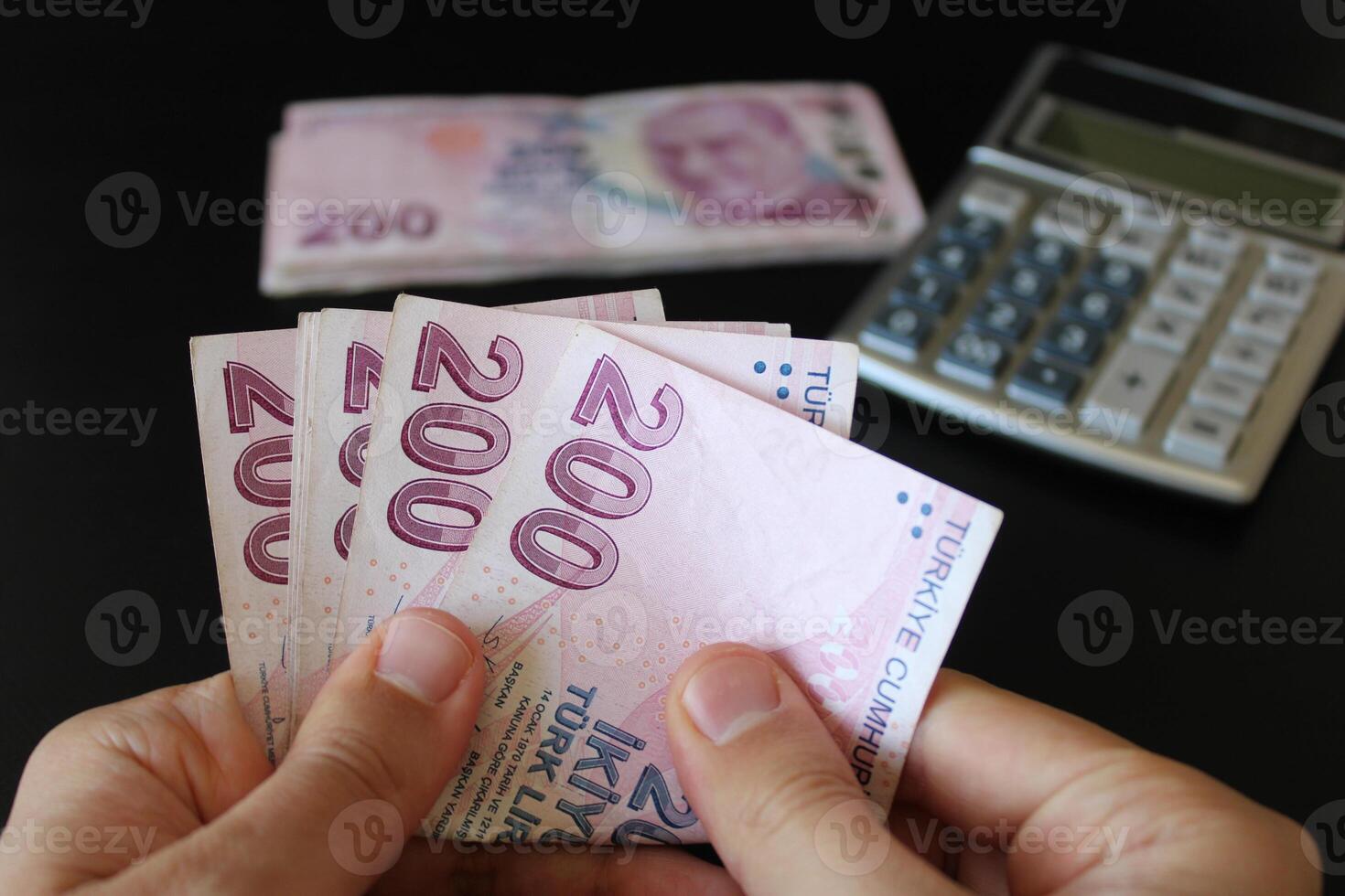 Turkish 200 lira banknotes.man counting Turkish money with his hand.Calculator in the background. The paper currency of Turkey. photo