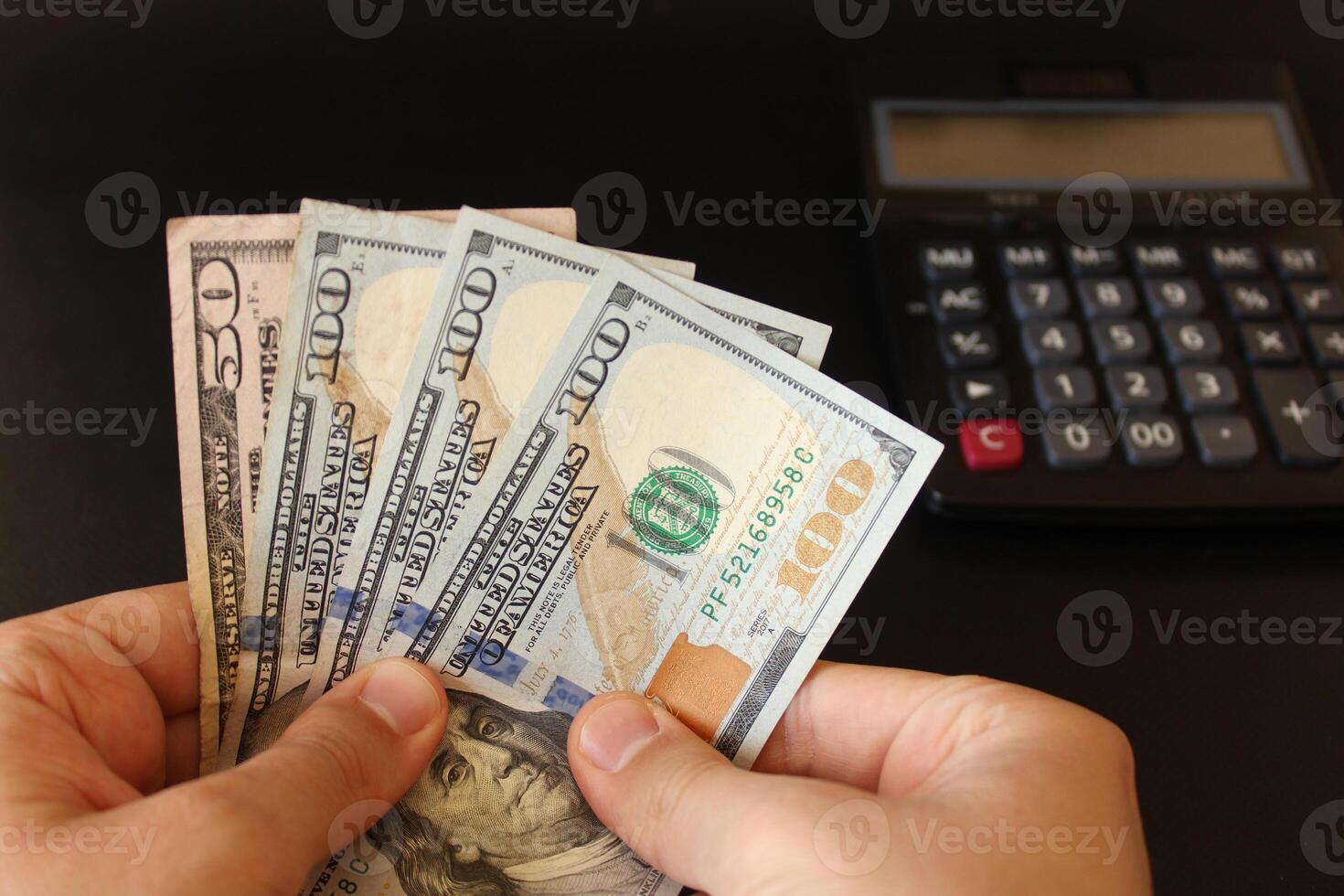 man counting US dollars money with his hand. US banknotes. The paper currency of usa .Calculator in the background. photo