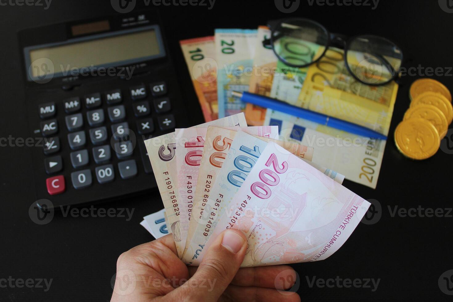 The paper currency of Turkey. Calculator in the background.Turkish lira banknotes. man counting Turkish money with his hand. photo
