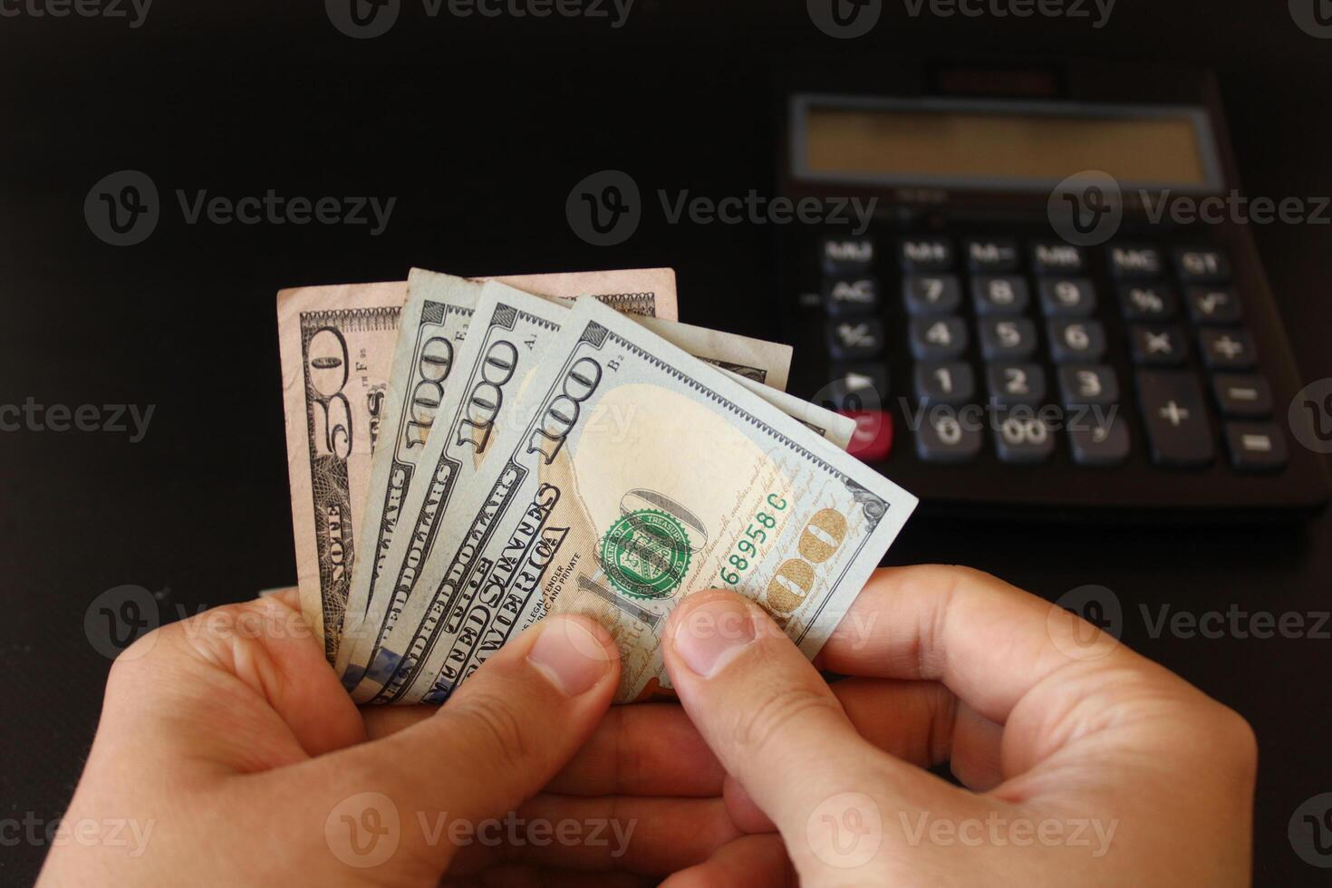 man counting US dollars money with his hand. US banknotes. The paper currency of usa .Calculator in the background. photo