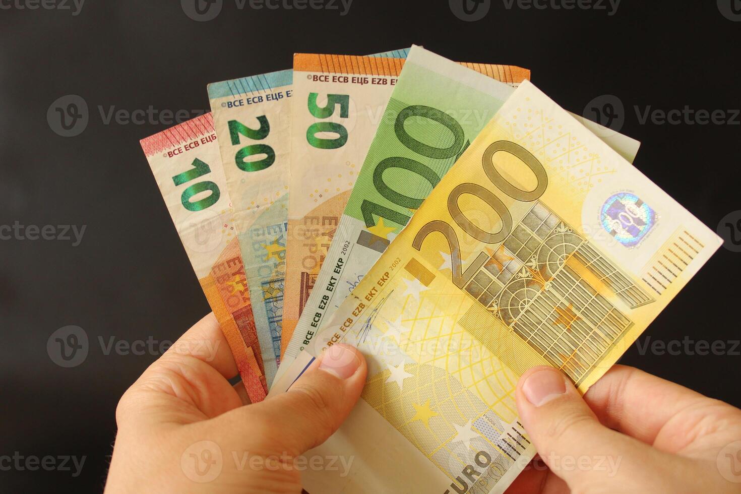man counting euro money with his hand. euro banknotes. The paper currency of europan union .Calculator in the background. photo