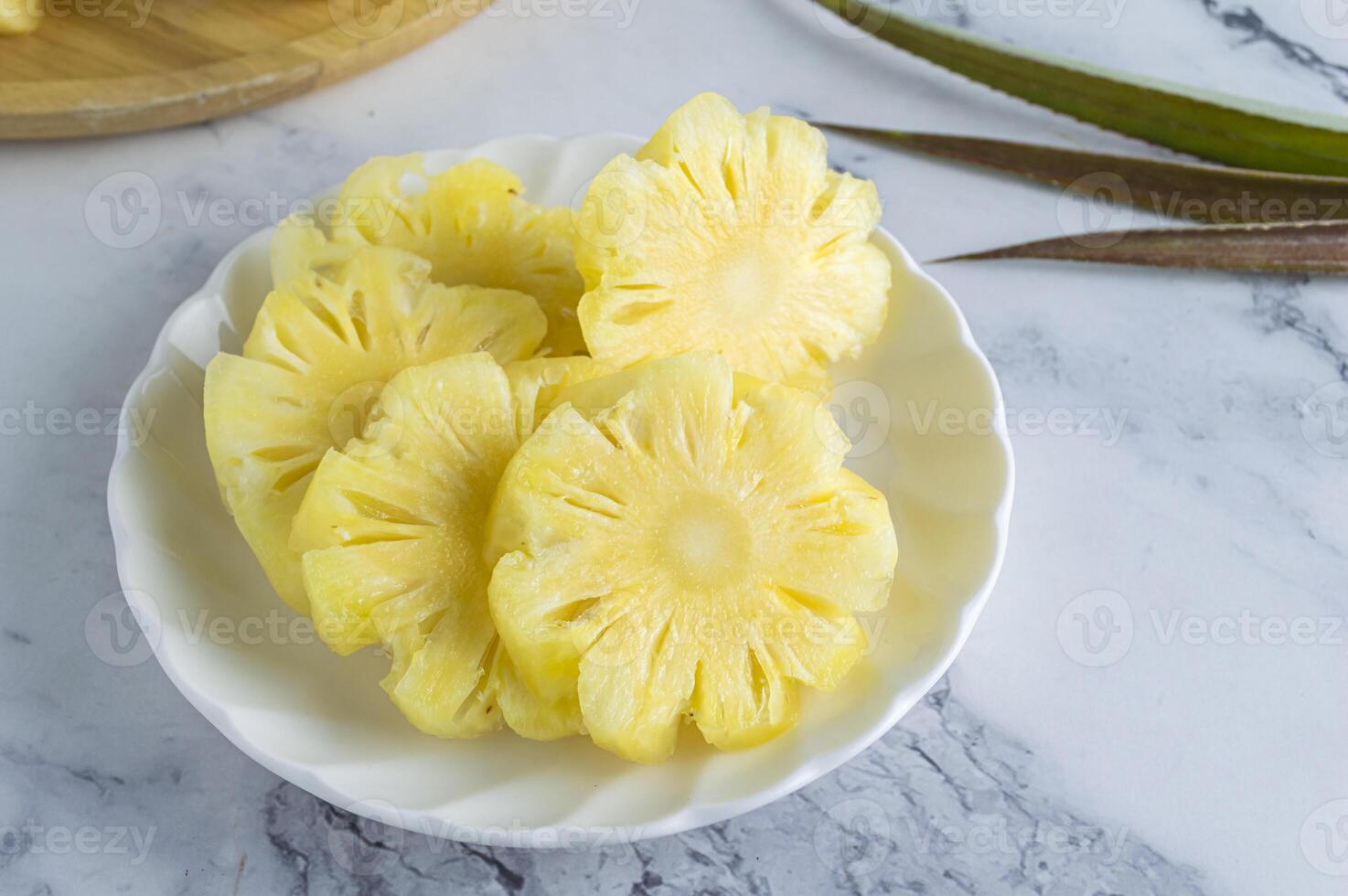 a bowl of sliced pineapple on a marble counter photo