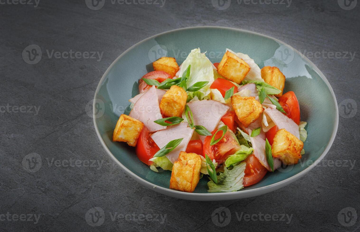 salad with ham and halloumi cheese on stone background photo