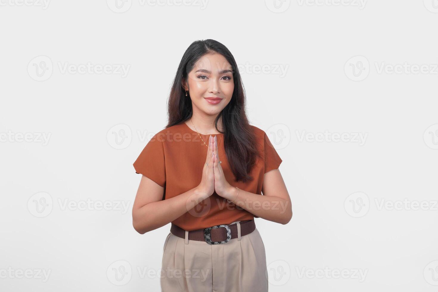 Smiling young Asian woman gesturing formal traditional greeting isolated over white background. photo