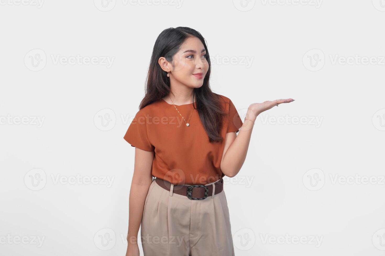 Happy Asian woman is smiling and presenting the copy space beside her over isolated white background. photo
