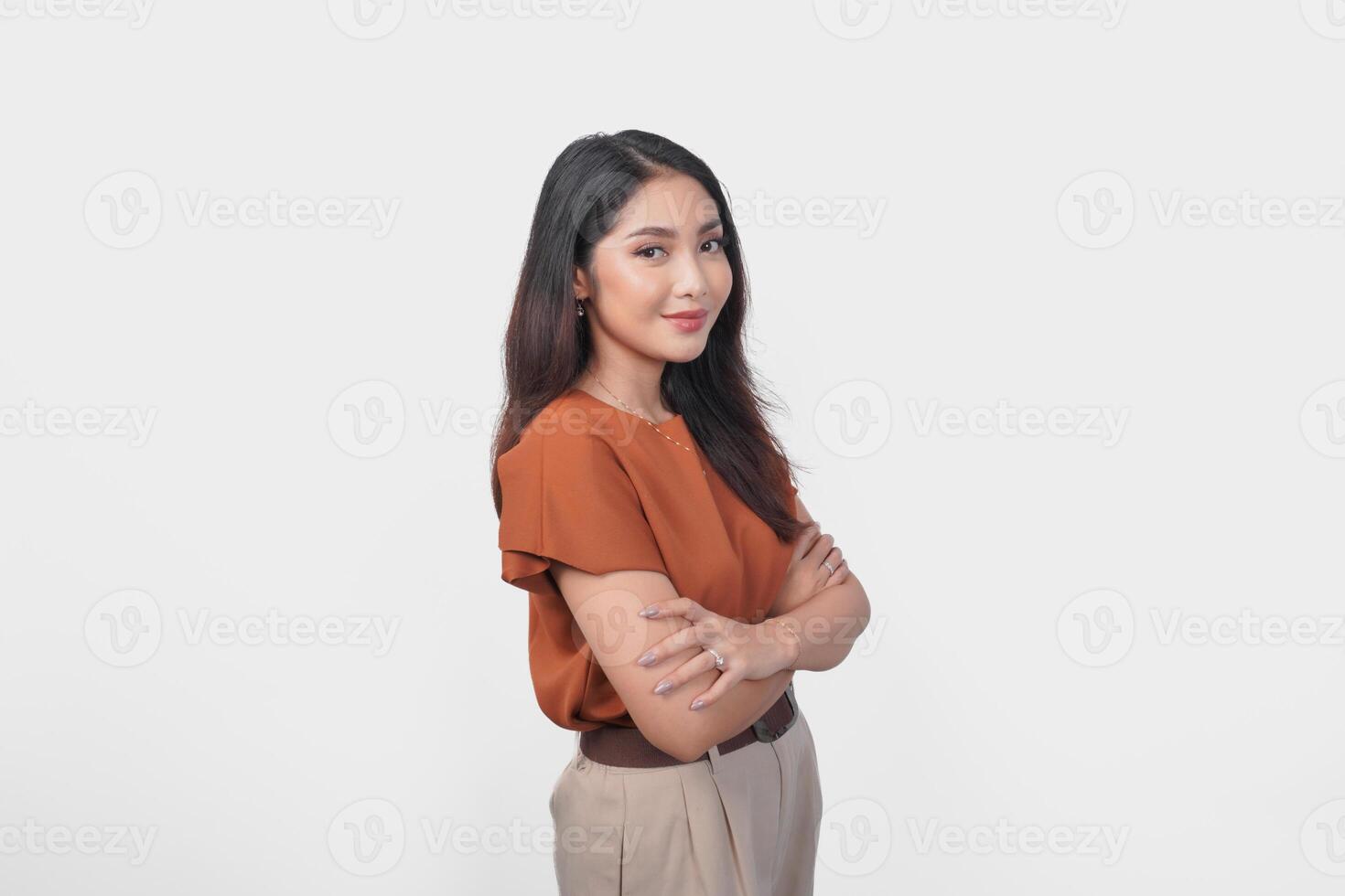 Smiling Asian woman in brown t-shirt standing with confidence expression and looking at the camera isolated over white background. photo
