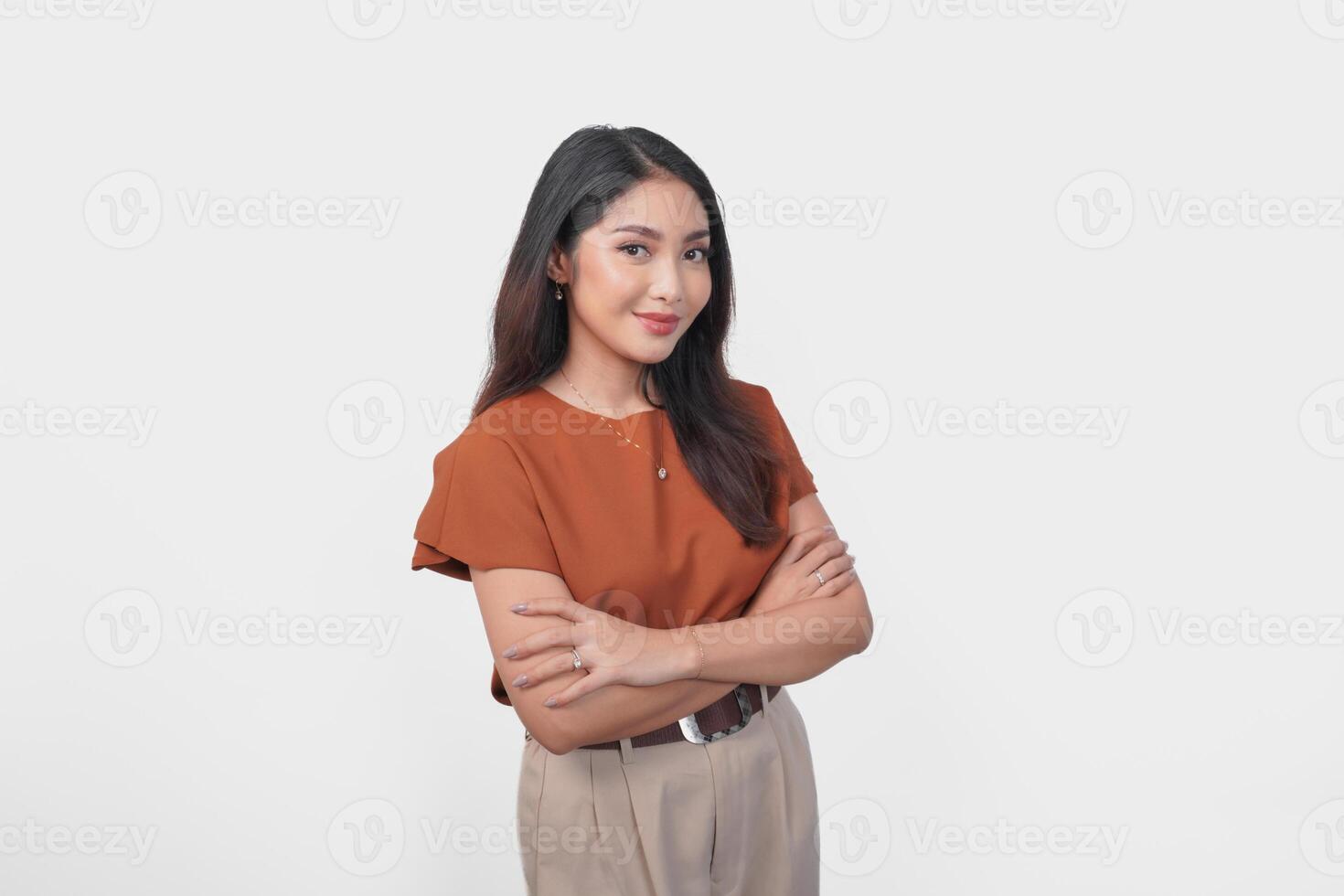 Smiling Asian woman in brown t-shirt standing with confidence expression and looking at the camera isolated over white background. photo