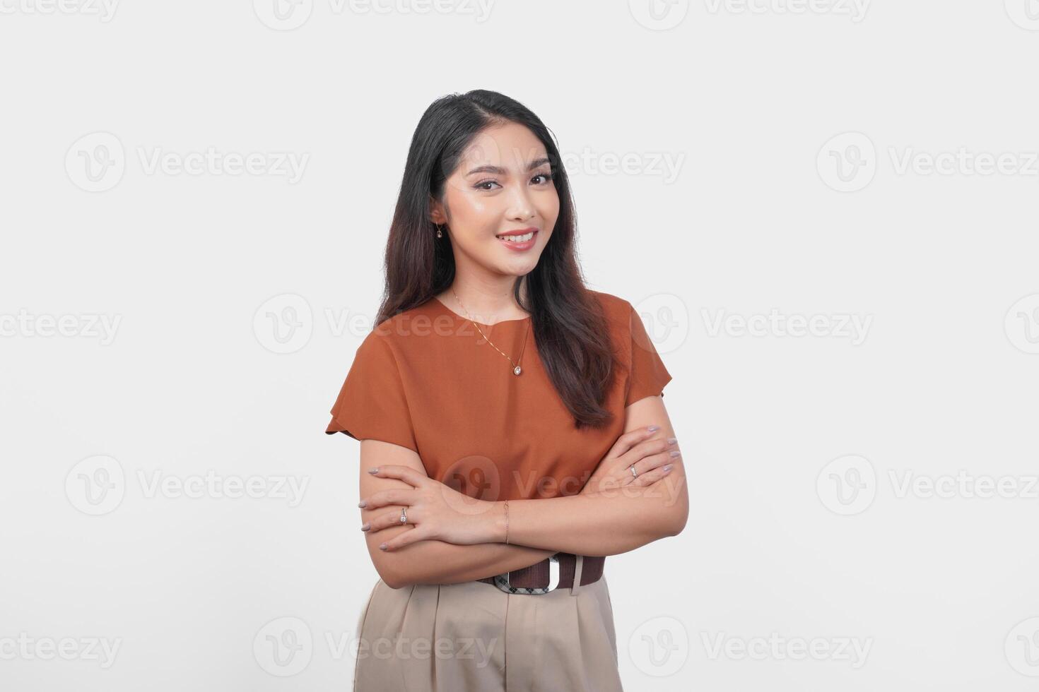Smiling Asian woman in brown t-shirt standing with confidence expression and looking at the camera isolated over white background. photo