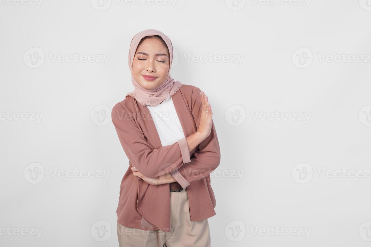 Young Asian Muslim woman wearing a hijab gesturing rejection or decline pose with copy space. photo
